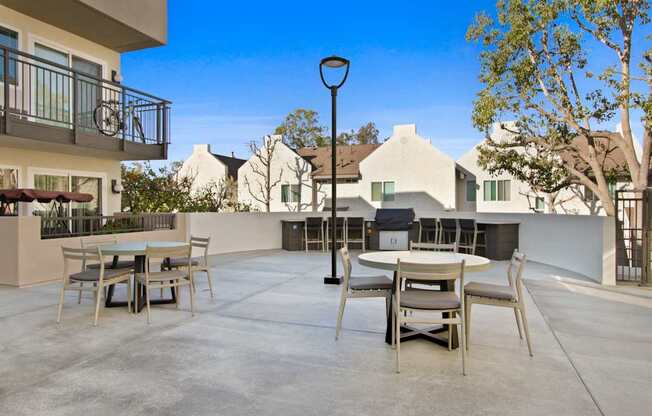 A patio with a table and chairs is surrounded by houses.