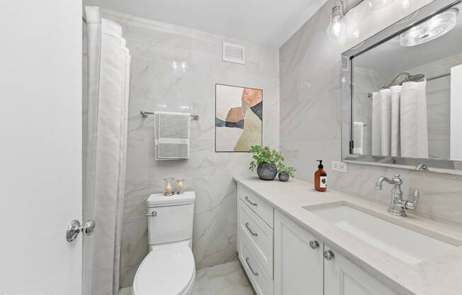 a bathroom with a sink toilet and a mirror