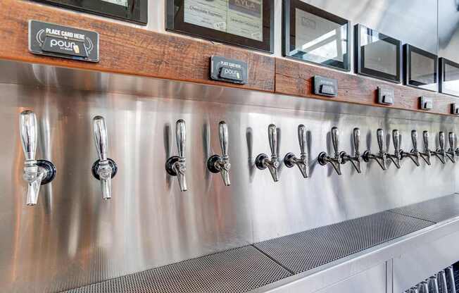 A stainless steel beer tap line with a wooden board above it.