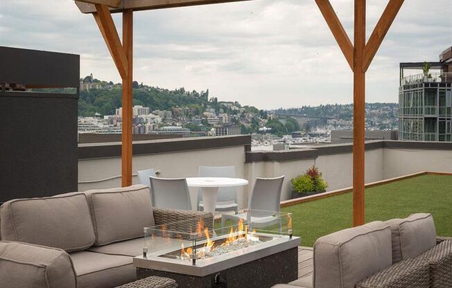 a patio with a fire pit and a view of the city