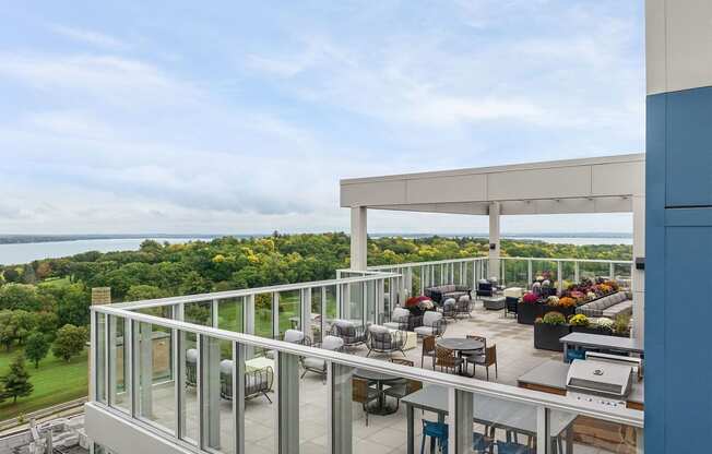 a balcony with tables and chairs and a view of the water