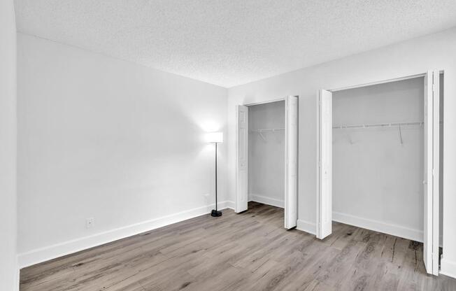 A room with a floor lamp and three open doors.