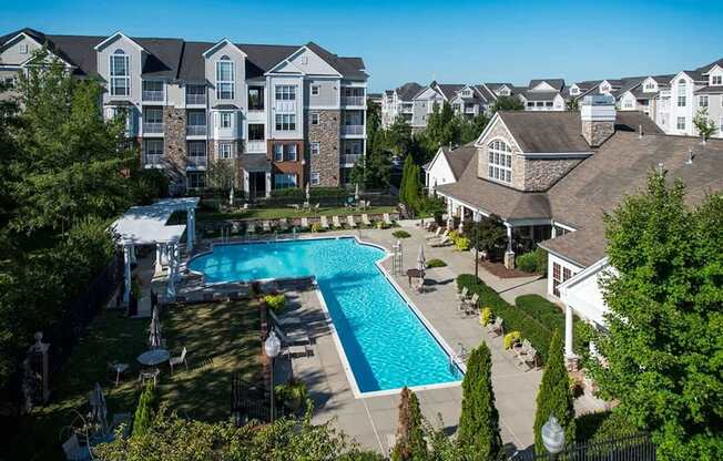 an aerial view of a swimming pool with apartments in the background