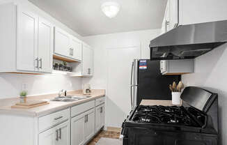 An upgraded kitchen with white cabinets and stainless steel appliances at Apple Ridge Apartments, Walker, MI