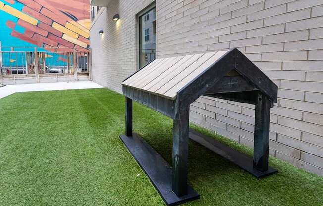 a bench in the yard of a building with artificial grass