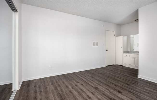 an empty living room with white walls and wood flooring