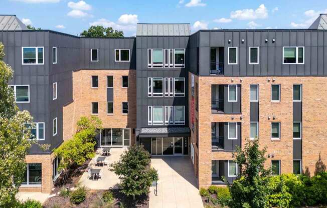 A modern building with a mix of brick and grey panels.