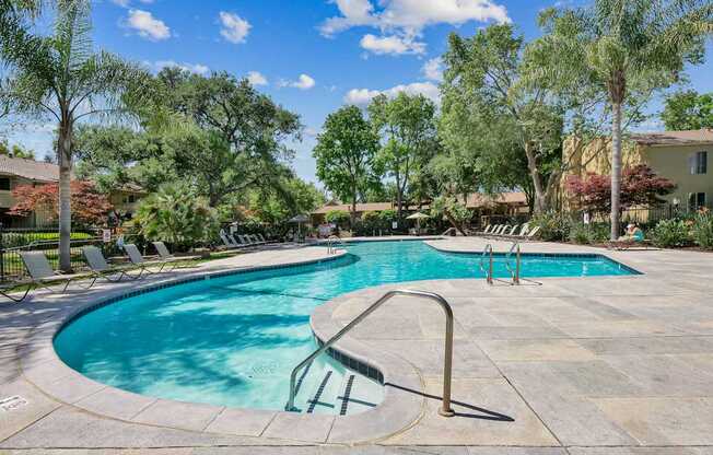 a swimming pool with trees in the background at Summerwood Apartments, California, 95050