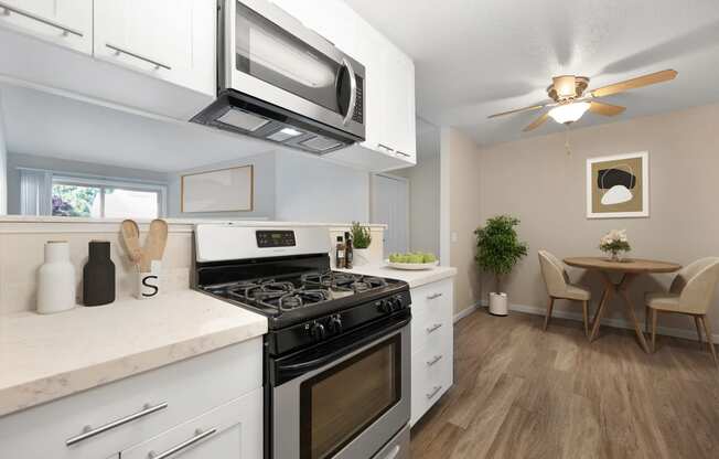 2 Bedroom, 2 Bath floor plan kitchen with hardwood inspired floors, stainless appliances including a microwave above the gas stove.