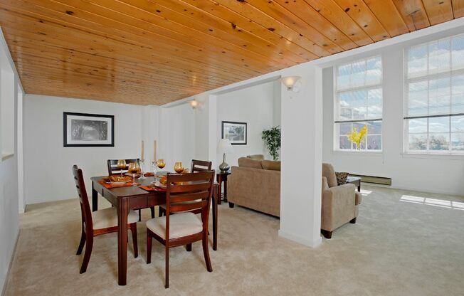 a dining room with a wooden ceiling and a table and chairs at Tindeco Wharf, Baltimore Maryland