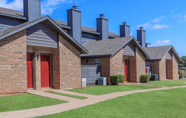 a large brick building with grass in front of a house