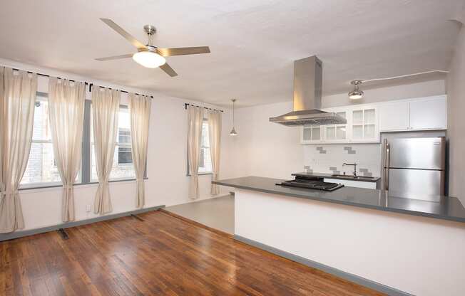 a living room with a kitchen and a ceiling fan at Del Mor, 90026