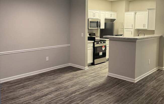 A kitchen area with a stove, oven, microwave, and refrigerator.