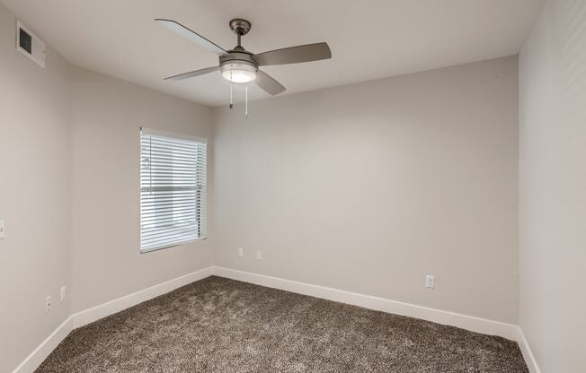 a bedroom with a ceiling fan and a window