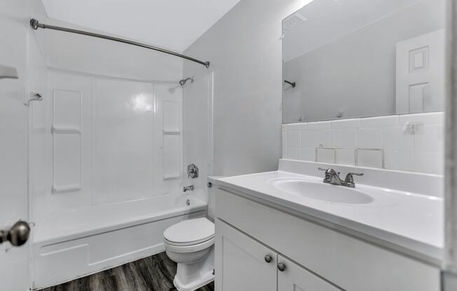 an empty bathroom with a sink toilet and shower