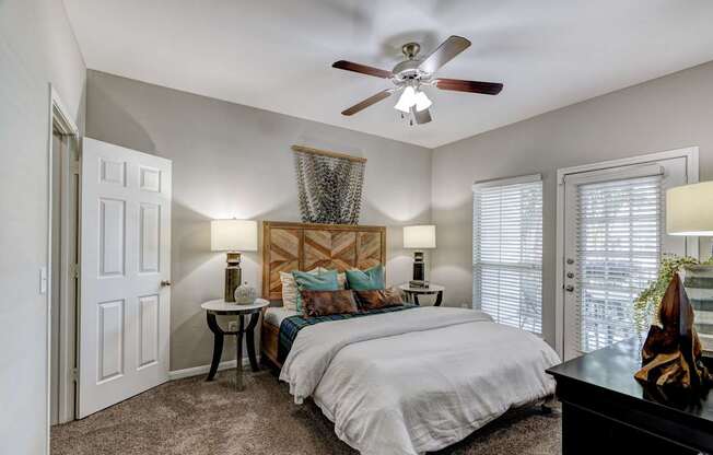 A bedroom with a large bed and a ceiling fan.