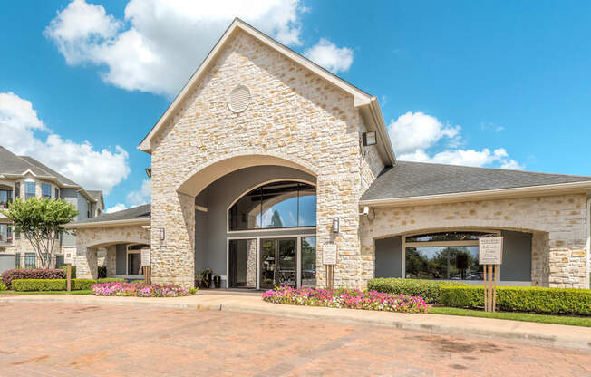 A house with a stone archway entrance and a grey roof.