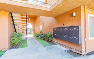 the entrance to a building with a mailbox and a staircase