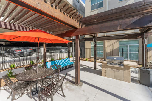 a patio with a table and chairs and a grill at Residences at 3000 Bardin Road, Grand Prairie, TX