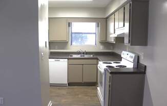 A kitchen with a white dishwasher and white oven.