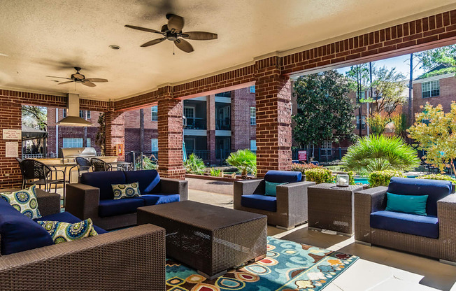 A patio with a wicker sofa and chairs.