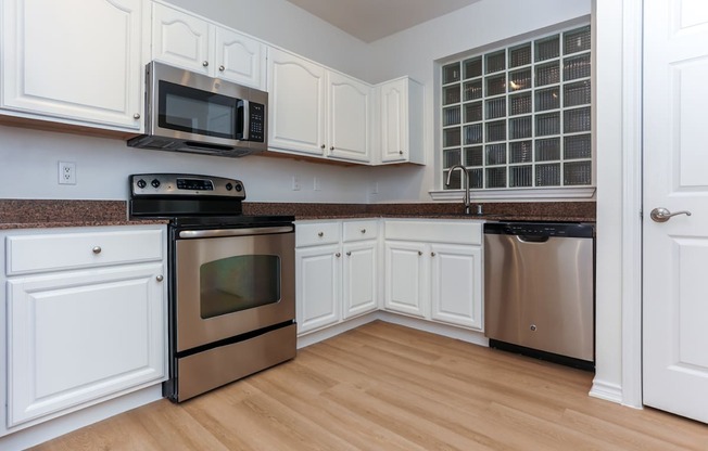 A kitchen with white cabinets and stainless steel appliances.