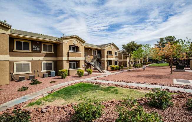 A building with a brown facade and a green lawn in front.