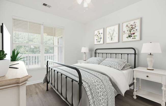 A bedroom with a black metal bed frame and a white bedspread.