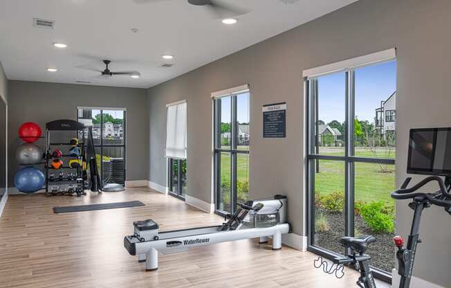 a home gym with exercise equipment and windows