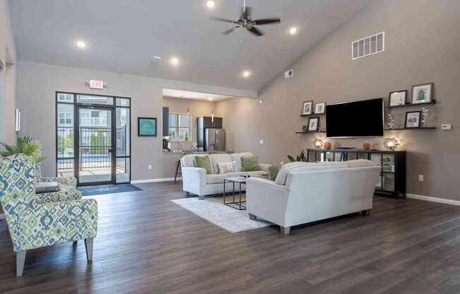 A living room with a white couch and a chair with a patterned cushion.
