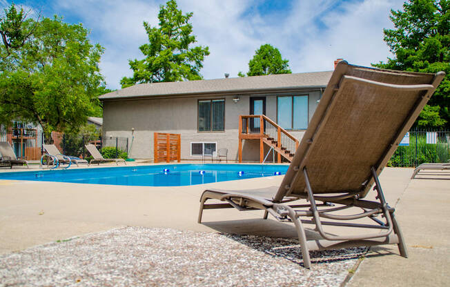 A chair is on the ground next to a pool.