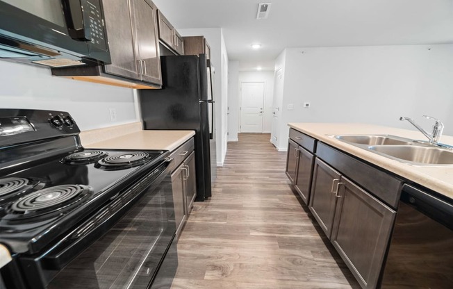 a kitchen with dark wood cabinets and stainless steel appliances  at Union at Wiley, Cedar Rapids, IA, 52404