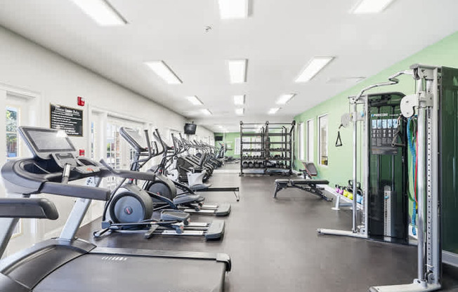 A gym with treadmills, weights, and exercise equipment.