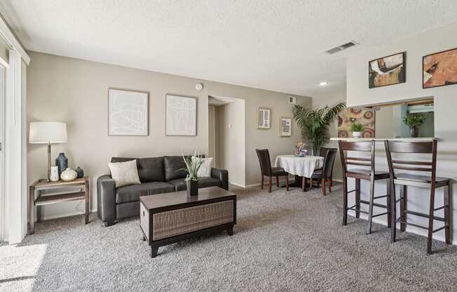 A living room with a grey carpet and furniture.