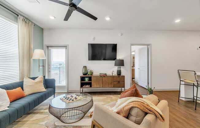 a spacious living room with a couch and a TV at Apex apartments in Colorado Springs, CO