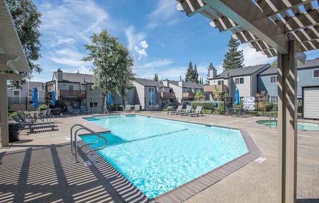 A large swimming pool with a shaded area next to it at Sierra Glen Apartments, California, 95621