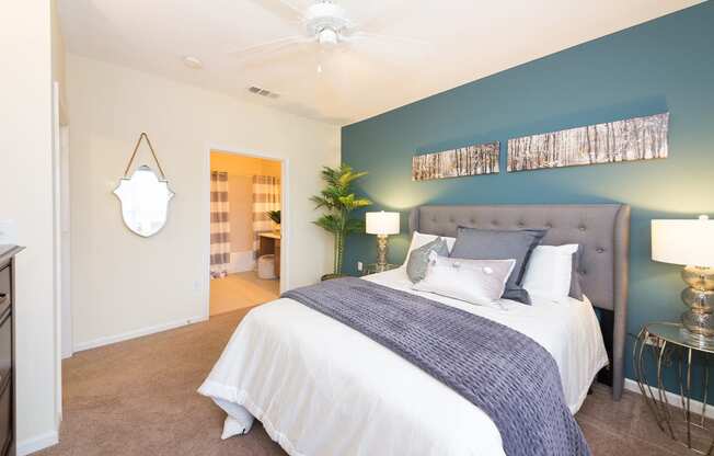 a bedroom with a large bed and a blue accent wall