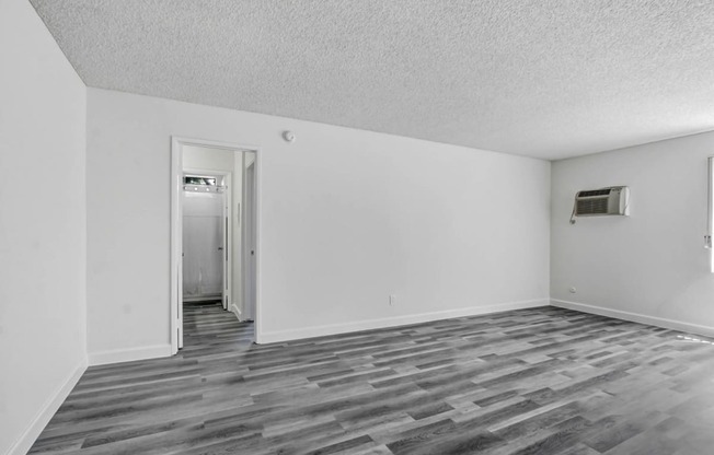 a bedroom with hardwood floors and white walls