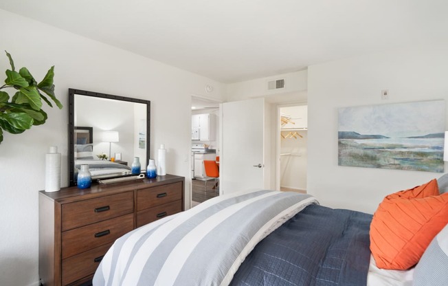 a bedroom with a bed and a dresser and a mirror