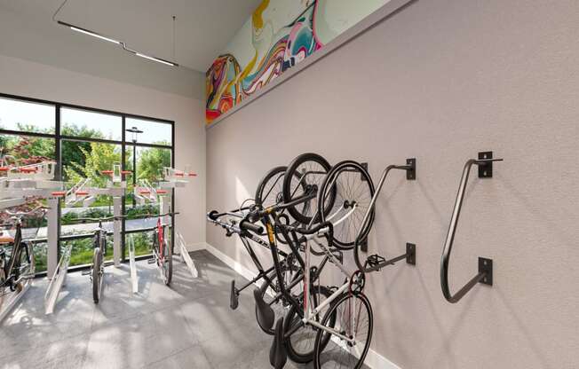 a room with bikes hanging on the wall and a window