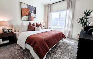 A bedroom with a large bed and a red blanket.