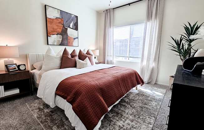 A bedroom with a large bed and a red blanket.
