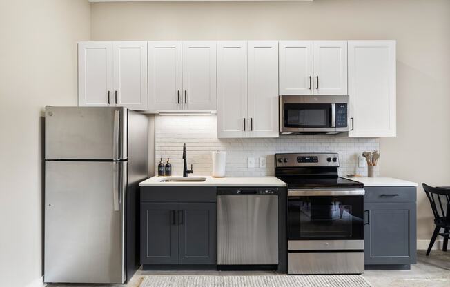 a kitchen with stainless steel appliances and white cabinets
