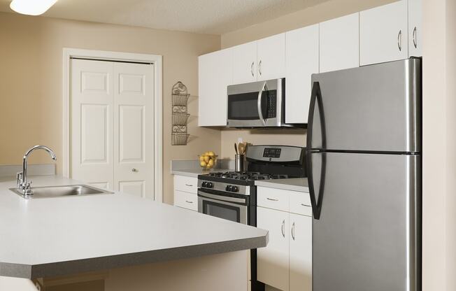 a kitchen with stainless steel appliances and white cabinets