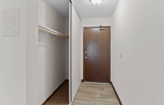 a hallway with a wooden door and a white wall