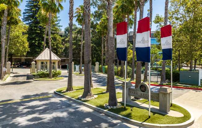 a park with flags and trees and a fountain