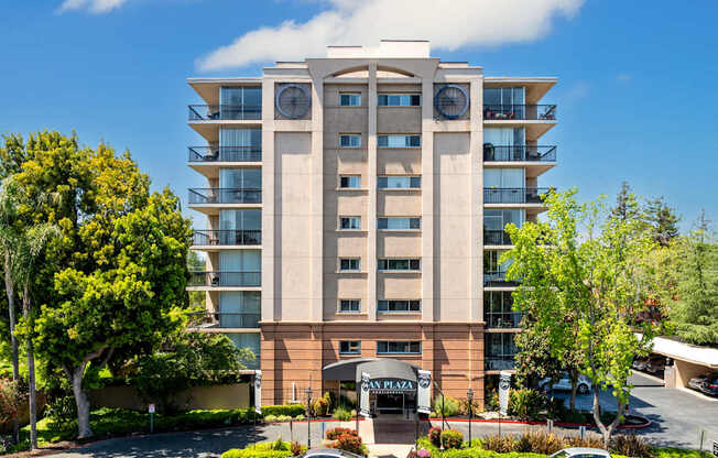 A large apartment building with a parking lot in front.