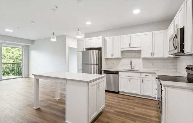 an open kitchen with white cabinets and stainless steel appliances