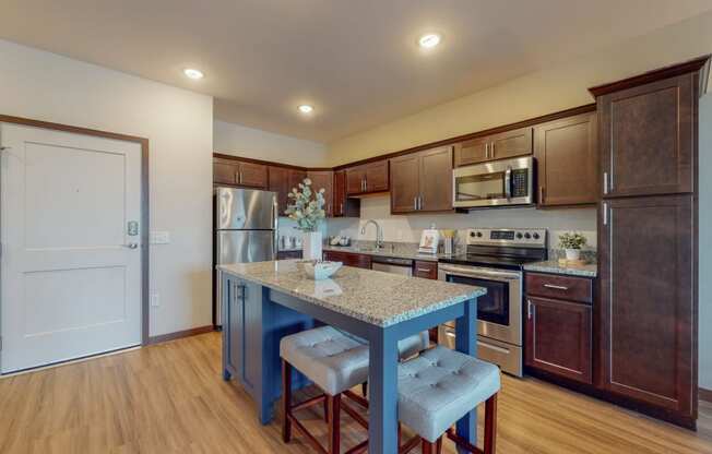 a kitchen with a large blue island with two stools in front of it