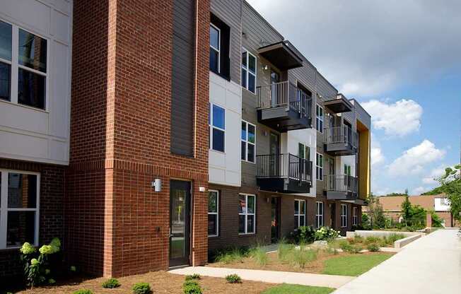 A modern apartment building with balconies and a brick facade.